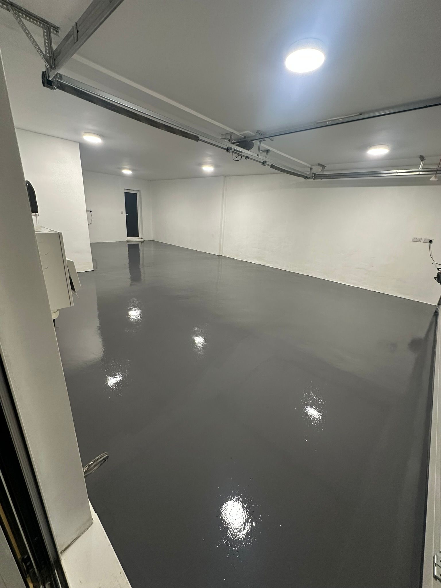 Finished gloss grey resin floor extending through a double garage