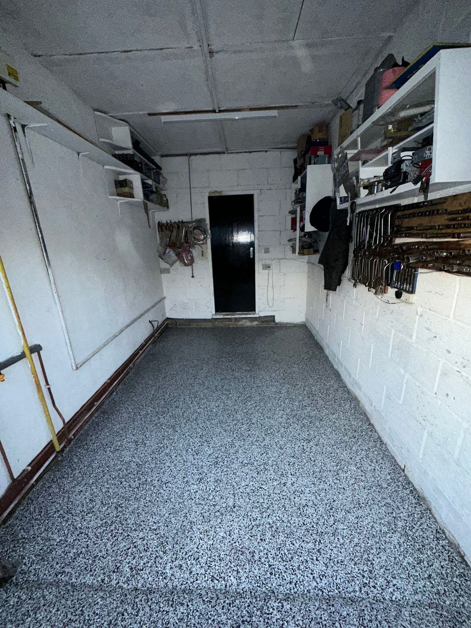 Fine monochrome flake floor in a compact home workshop