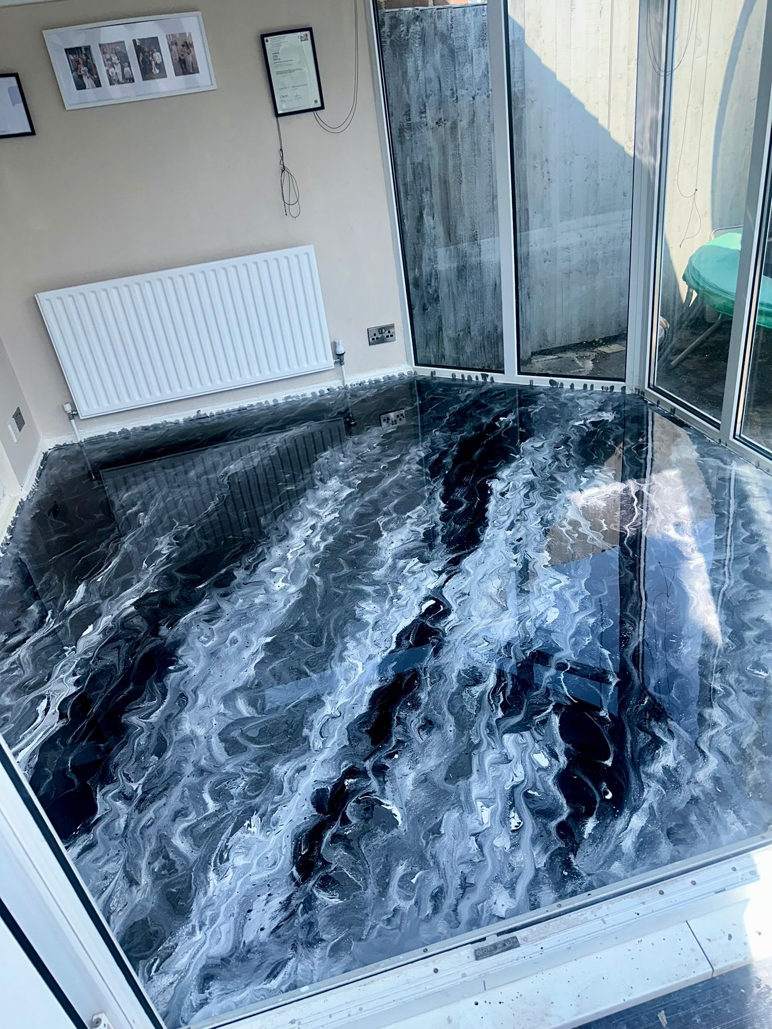 Black and white flowing decorative resin floor in a conservatory