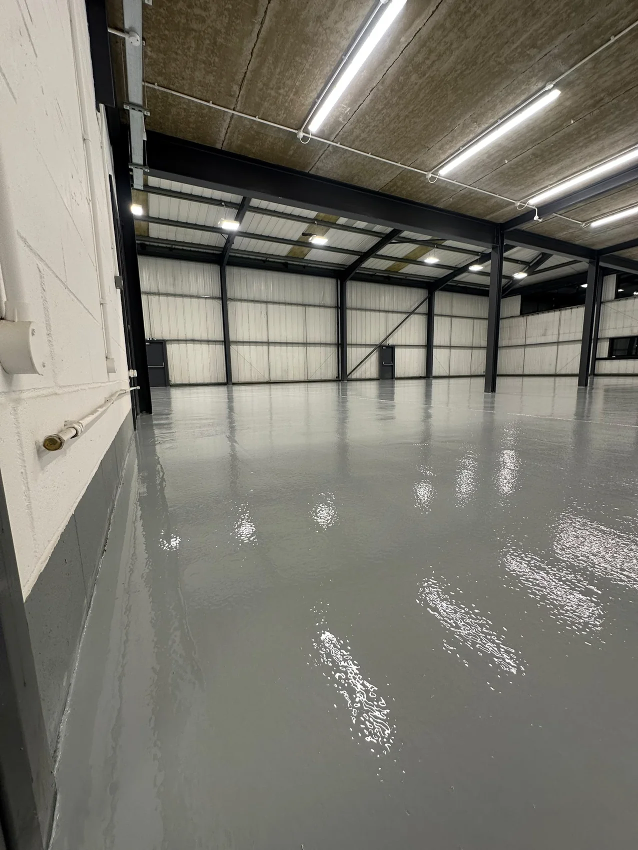 Grey coating extending between the warehouse steel columns